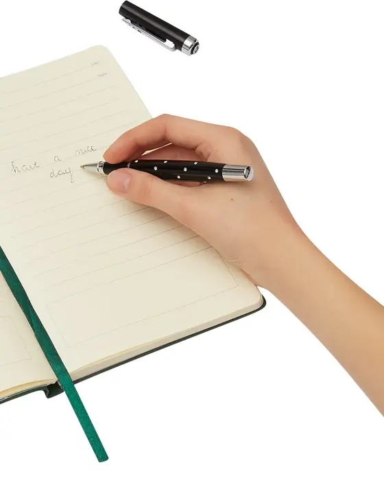 Writing in a notebook with a RIGA rollerball pen with Swarovski crystals